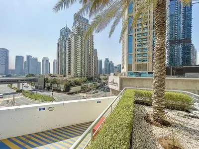 a palm tree on a city street with tall buildings at MAG 218 Tower - Elegant One Bedroom in Dubai