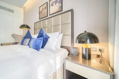 a bedroom with a large white bed with blue pillows at Dazzling Studio Apartment in Business Bay l City View in Dubai