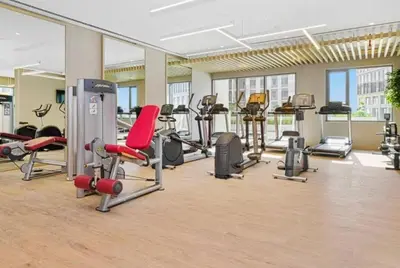 a gym with a lot of treadmills and machines at 1BR Apartment in Park Heights 2 Dubai Hills in Dubai