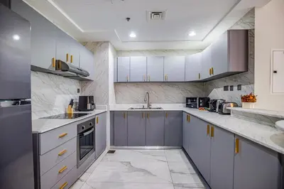 a kitchen with white cabinets and a sink at Spacious 1BR in the iconic Torch Tower, Dubai Marina - Allsopp&Allsopp in Dubai