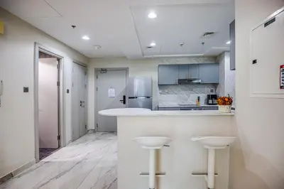 a kitchen with a counter and two stools at Spacious 1BR in the iconic Torch Tower, Dubai Marina - Allsopp&Allsopp in Dubai