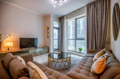 a living room with a couch and a tv at Spacious 1BR in the iconic Torch Tower, Dubai Marina - Allsopp&Allsopp in Dubai
