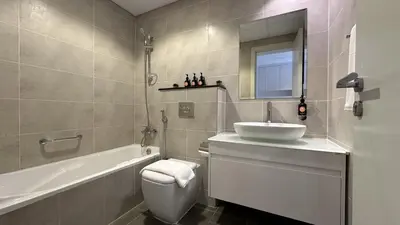 a bathroom with a sink and a toilet and a tub at EasyGo - Carson Tower C Damac Hills Studio in Dubai
