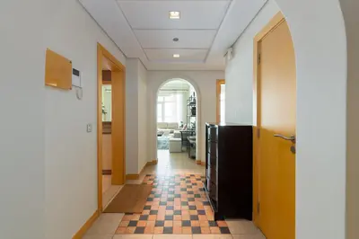a hallway with a black refrigerator and a checkered floor at Shoreline 7, Palm Jumeirah - Mint Stay in Dubai