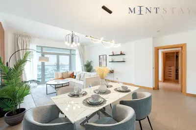 a white living room with a table and chairs at Shoreline 7, Palm Jumeirah - Mint Stay in Dubai