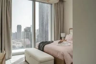 a bedroom with a bed and a large window at 4BR - Burj and Fountain View - Opposite Dubai Mall in Dubai