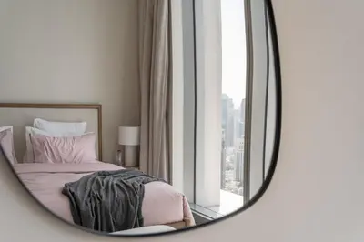 a mirror reflecting a bedroom with a bed and a window at 4BR - Burj and Fountain View - Opposite Dubai Mall in Dubai