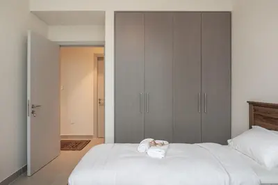 a bedroom with a large white bed with towels on it at 4BR - Burj and Fountain View - Opposite Dubai Mall in Dubai