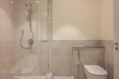 a bathroom with a toilet and a glass shower at 4BR - Burj and Fountain View - Opposite Dubai Mall in Dubai