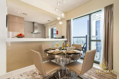 a kitchen and dining room with a glass table and chairs at Damac Paramount - Luxurious 2BR - Stunning Dubai Canal View - High Level in Dubai