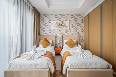 a bedroom with two beds with white sheets and gold pillows at Super High Infinity Pool & Stunning Burj Khalifa View, 3-Bedroom Apartment at Paramount Hotel Midtown in Dubai
