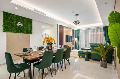 a dining room with a table and green chairs at Super High Infinity Pool & Stunning Burj Khalifa View, 3-Bedroom Apartment at Paramount Hotel Midtown in Dubai