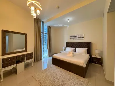 a bedroom with a bed with a mirror and a television at Luxury apartment 3 beds Marina view in Dubai