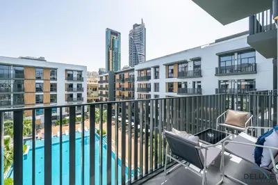 a balcony with a view of a pool and buildings at Lovely 2BR at Belgravia Square, JVC by Deluxe Holiday Homes in Dubai