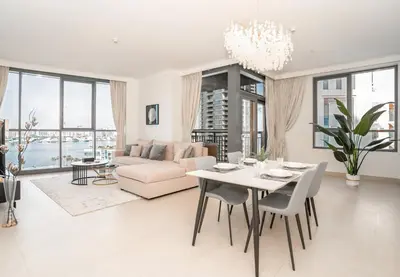 a living room with a table and a couch at Superior New Luxury Living 2BR Apt Dubai Creek Harbour in Dubai