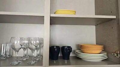 a shelf with wine glasses and plates and bowls at MH- Act Tower - Downtown 1BHK-REF4606 in Dubai