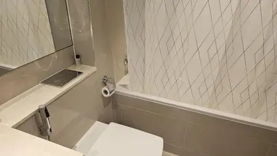 a bathroom with a toilet and a sink and a mirror at MH- Act Tower - Downtown 1BHK-REF4606 in Dubai