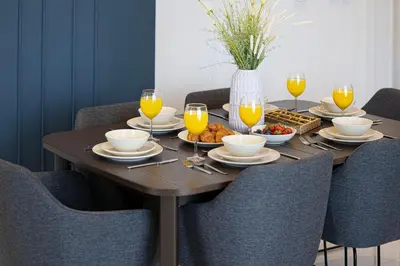 a wooden table with food and glasses of orange juice at SmartStay at Paramount Tower - Sea and Downtown Views - Infinity Pool - Modern Luxury Residences in Dubai