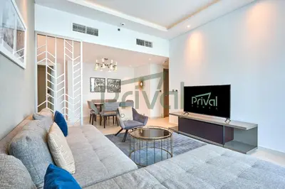 a living room with a couch and a tv at Prival - Prive in Dubai