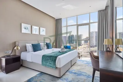 a bedroom with a bed and a desk and a large window at Prival - Prive in Dubai