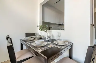 a dining room with a table with plates and glasses at GuestReady - Marvellous home at Binghatti Heights in Dubai