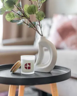 a white coffee mug sitting on a table with a vase at GuestReady - Marvellous home at Binghatti Heights in Dubai