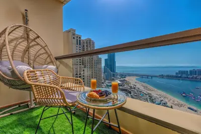 a balcony with two chairs and a table with food at Luxury Dubai Eye View Living - Beach access I Marina Walk in Dubai