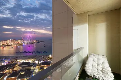 a room with a view of the ocean and a ferris wheel at Luxury Dubai Eye View Living - Beach access I Marina Walk in Dubai