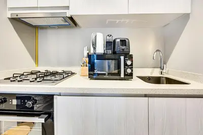 a kitchen with a sink and a stove top oven at Brand new cozy 1 bedroom in Business Bay in Dubai