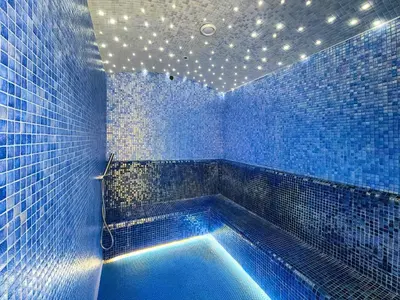 a blue tiled bathroom with a blue tub with lights at Brand new cozy 1 bedroom in Business Bay in Dubai