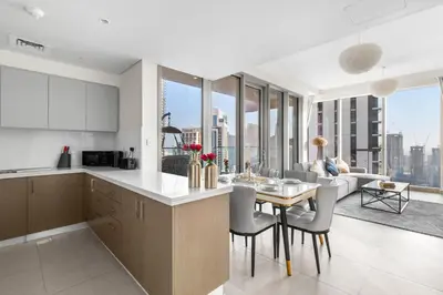 a kitchen and living room with a table and chairs at Luxury 4-Bed Escape in Downtown Dubai That Sleeps 9 in Dubai