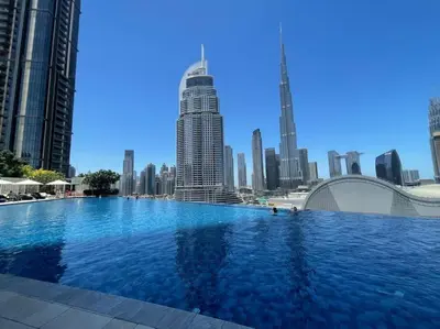 a large swimming pool in a city with tall buildings at The Address Fountain Views - Residence 2 Bedroom with Burj Khalifa view and access to Dubai mall in Dubai