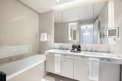a white bathroom with two sinks and a bath tub at The Address Fountain Views - Residence 2 Bedroom with Burj Khalifa view and access to Dubai mall in Dubai