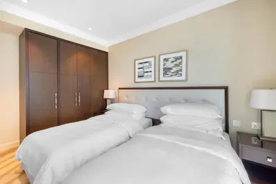 two beds in a bedroom with white sheets at The Address Fountain Views - Residence 2 Bedroom with Burj Khalifa view and access to Dubai mall in Dubai