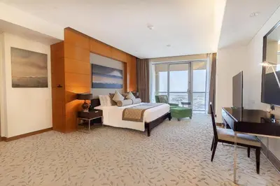 a hotel room with a bed and a television at Four Apple EMAAR Fashion Avenue Deluxe Studio in Dubai