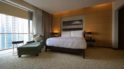 a hotel room with a bed and a chair at Four Apple EMAAR Fashion Avenue Deluxe Studio in Dubai