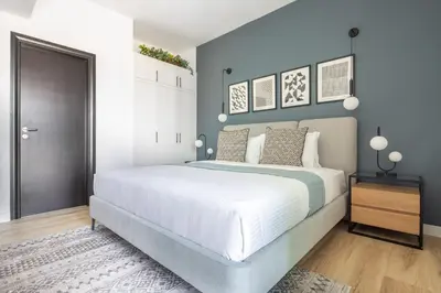 a bedroom with a large white bed and blue walls at Frank Porter - La Riviera Tower in Dubai