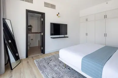 a bedroom with a bed and a flat screen tv at Frank Porter - La Riviera Tower in Dubai