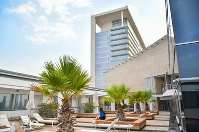 a person sitting on a patio in front of a building at Heart of DIFC: SKY Gardens Modern Chic Studio in Dubai