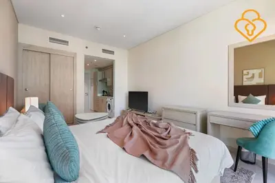 a bedroom with a white bed with blue pillows at Keysplease Studio W/Beach Access near Mall, Palm Jumeirah in Dubai