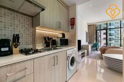 a kitchen with a sink and a washer and dryer at Keysplease Studio W/Beach Access near Mall, Palm Jumeirah in Dubai