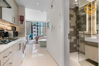 a kitchen with a glass door leading to a bathroom at Keysplease Studio W/Beach Access near Mall, Palm Jumeirah in Dubai