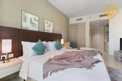 a bedroom with a large bed with white sheets and blue pillows at Keysplease Studio W/Beach Access near Mall, Palm Jumeirah in Dubai