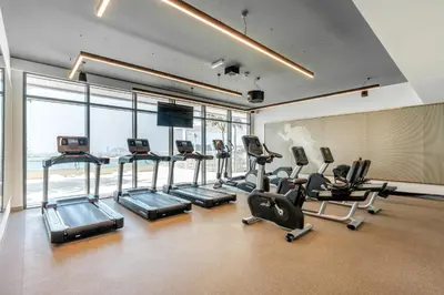 a gym with cardio equipment in a building with windows at Stayis I Beachfront Luxury 1BR with Private Access in Dubai