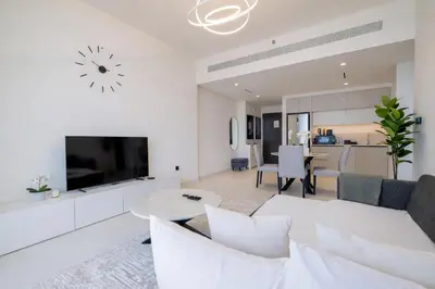 a living room with a white couch and a tv at Sea and Palm View from 1BD apt in Beachfront in Dubai