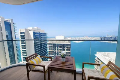 a balcony with a table and chairs and the ocean at Sea and Palm View from 1BD apt in Beachfront in Dubai
