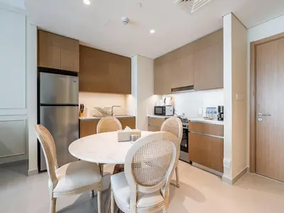 a kitchen with a table and chairs in a room at Sunset Creek Oasis: 1BR Gem Luxury Beach Apartment in Dubai