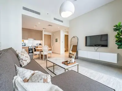 a living room with a couch and a flat screen tv at Sunset Creek Oasis: 1BR Gem Luxury Beach Apartment in Dubai