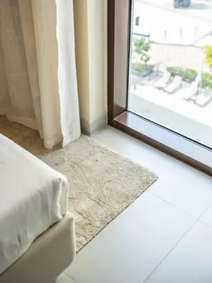 a room with a window with a rug next to it at Sunset Creek Oasis: 1BR Gem Luxury Beach Apartment in Dubai