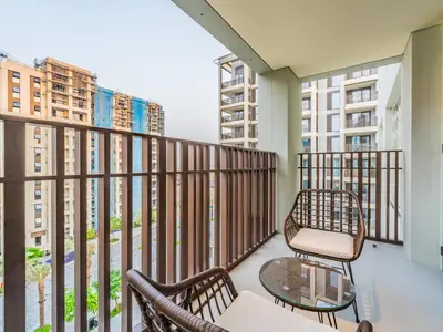 a balcony with two chairs and a table at Pearl of Creek Beach: 1BR Luxury Beach Apartment in Dubai